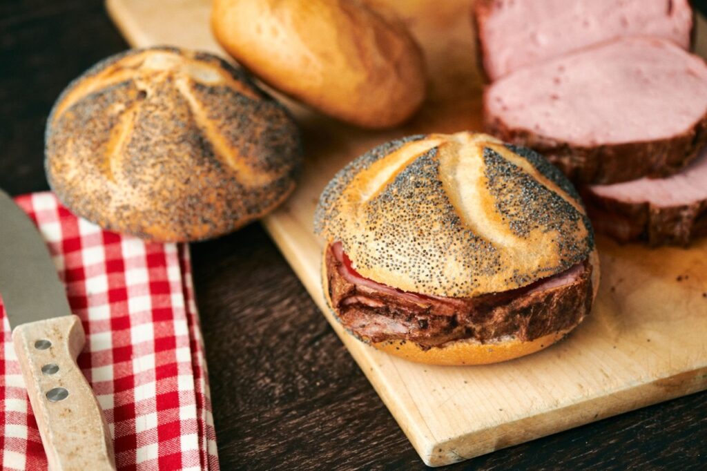 Frisch gebackenes Leberkäse-Brötchen mit knusprigem Mohnbrötchen und hausgemachtem Leberkäse aus dem Ofen