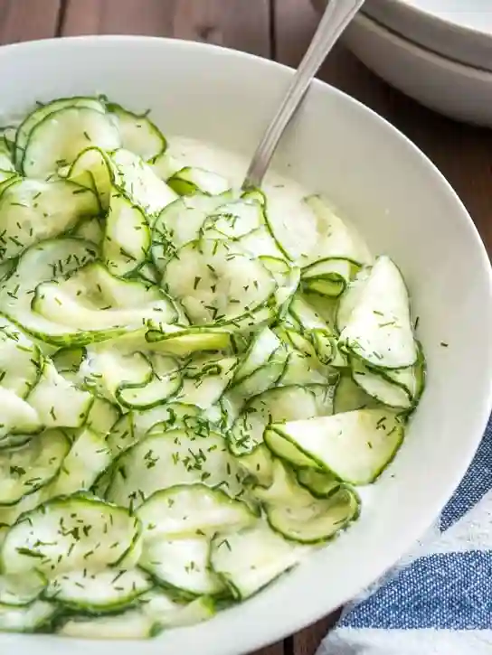 Gurkensalat mit Schmand und Dill in weißer Schüssel serviert