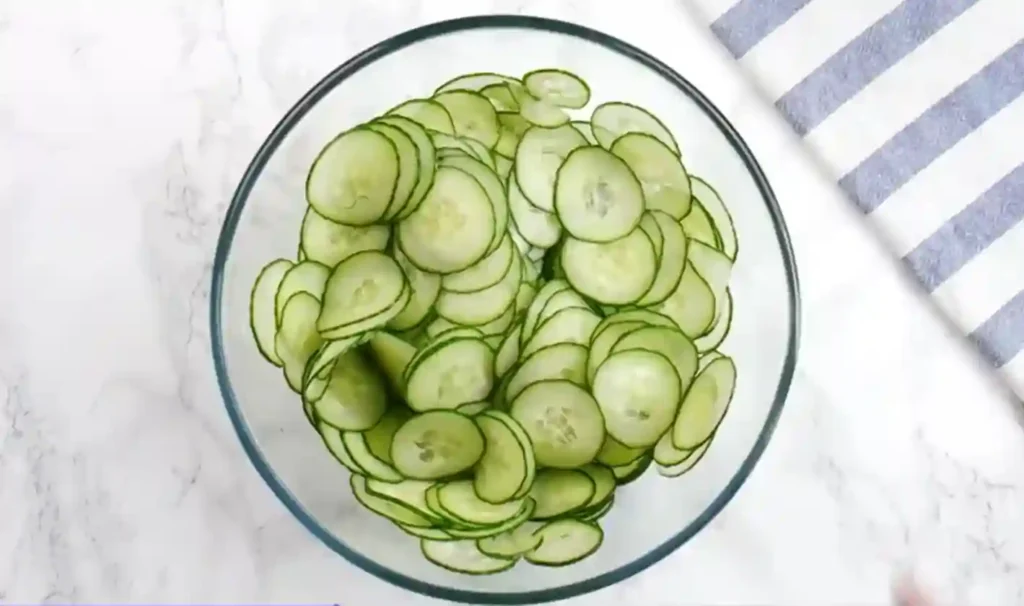 Dünn geschnittene Gurken in einer Glasschüssel – Gurkensalat Rezept Vorbereitung