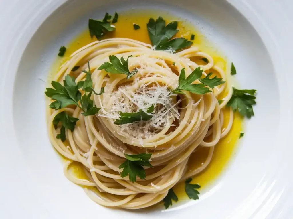 Aglio e Olio Pasta auf rustikalem Holztisch serviert.

