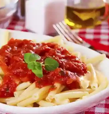 DDR Tomatensoße ohne Ketchup serviert mit Makkaroni und frischen Kräutern.