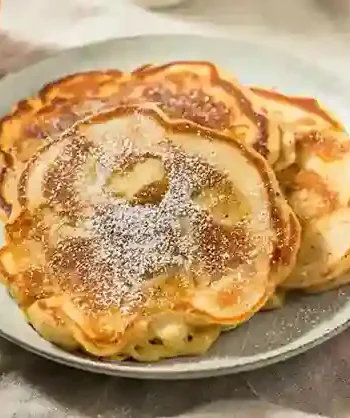 Goldbraune Apfelpfannkuchen nach Omas Rezept, serviert mit Puderzucker – ein einfaches und leckeres Apfelpfannkuchen Rezept.