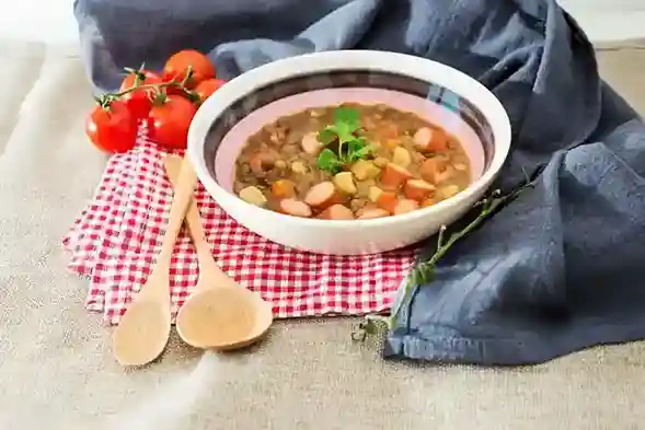 Linsensuppe Schnellkochtopf – Herzhafte Linsensuppe mit Würstchen und Gemüse, serviert mit frischen Kräutern.