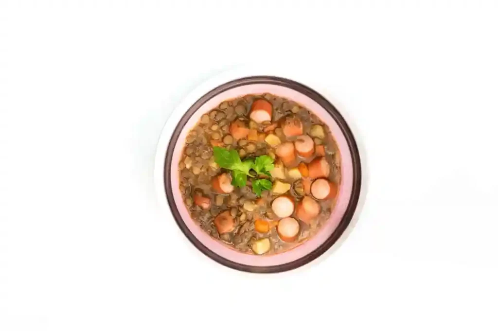 Linsensuppe Schnellkochtopf – Deftige Linsensuppe mit Würstchen und Gemüse, serviert in einer Schüssel.