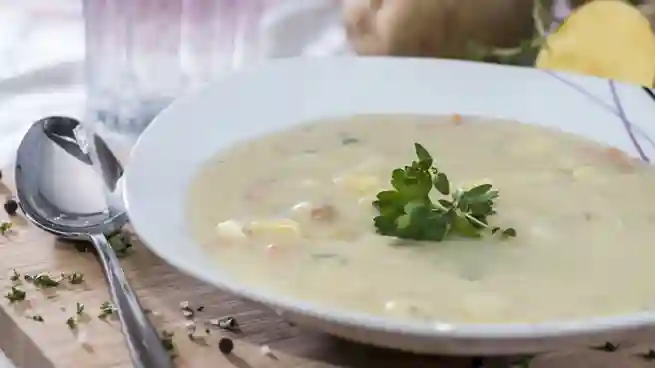 Ein Teller cremige Kartoffelsuppe mit frischer Petersilie garniert – das perfekte Kartoffelsuppe Rezept vegetarisch für kalte Tage.