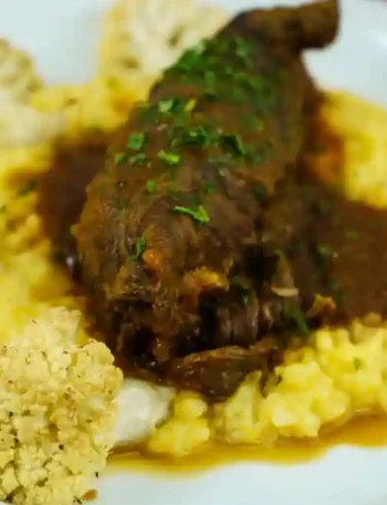 Rouladen im Schnellkochtopf serviert mit cremigem Kartoffelpüree, geröstetem Blumenkohl und einer herzhaften Sauce, garniert mit frischer Petersilie.