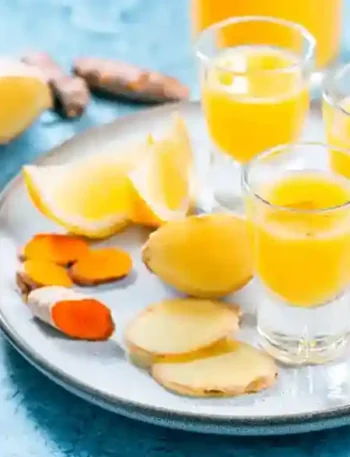 Frische Kurkuma Ingwer Shots mit Zitrone auf einem Tablett – der perfekte Immunbooster für mehr Energie und Gesundheit.