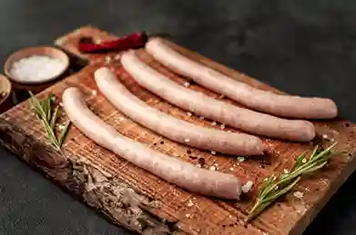 Hausgemachte Würste auf einem rustikalen Holzbrett – Rezept Wurst zum Selbermachen