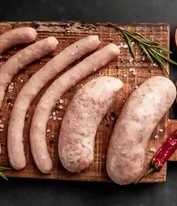 Hausgemachte Wurst auf Holzbrett mit Salz, Pfeffer und Kräutern – Perfektes Rezept Wurst
