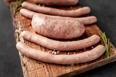 Frische selbstgemachte Würste auf einem Holzbrett – Rezept Wurst