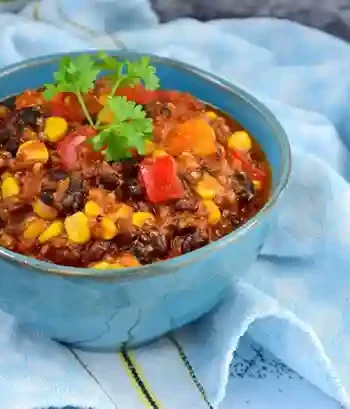 Veganes Chili mit Mais, Bohnen und Linsen in einer blauen Schüssel – chili sin carne rezept einfach und schnell