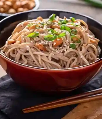 Leckeres Mie Nudeln Rezept mit Erdnüssen und Frühlingszwiebeln in einer roten Schüssel serviert