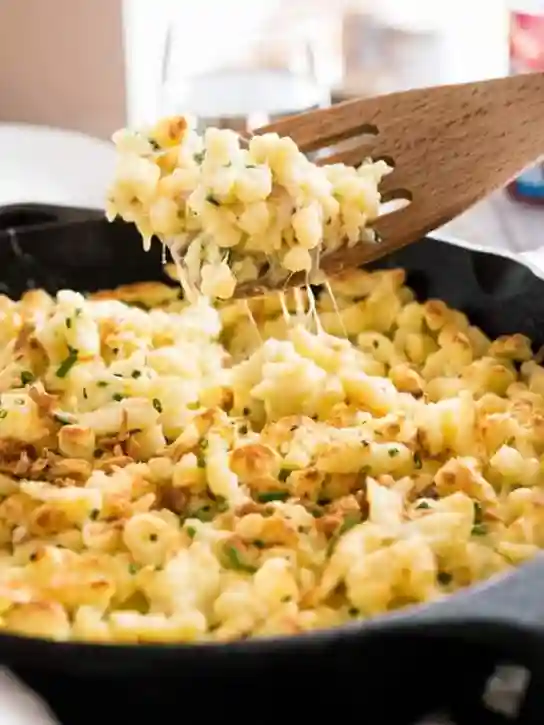 spätzle rezepte – käsespätzle frisch aus der Pfanne mit geschmolzenem Käse und Röstzwiebeln