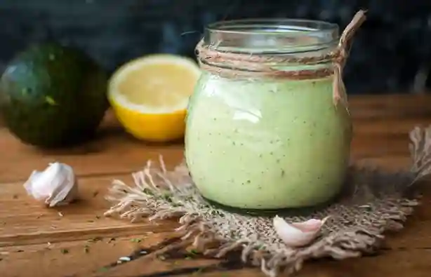 Köstliches Avocado Dressing für Salat in einem Glas, zubereitet mit frischem Zitronensaft und Knoblauch, perfekt für deinen Salat.