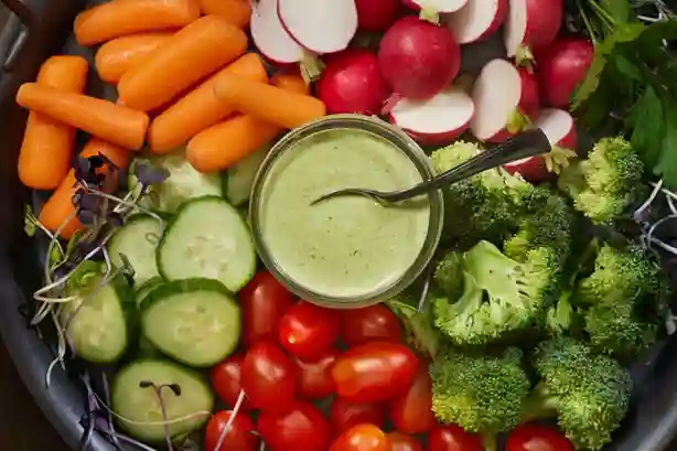 Salat mit Avocado Dressing, featuring fresh vegetables like cucumbers, tomatoes, radishes, and broccoli.