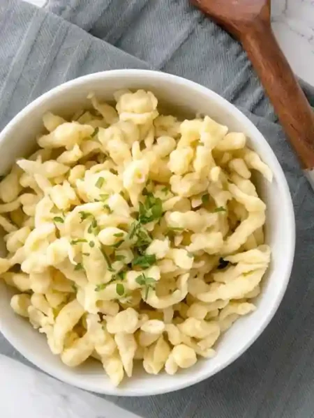 Spätzle selber machen ohne Spätzlepresse – frisch zubereitet in einer weißen Schüssel mit Kräutern garniert