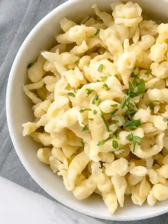 Spätzle selber machen ohne Spätzlepresse – traditionelle Zubereitung in einer weißen Schüssel mit frischen Kräutern