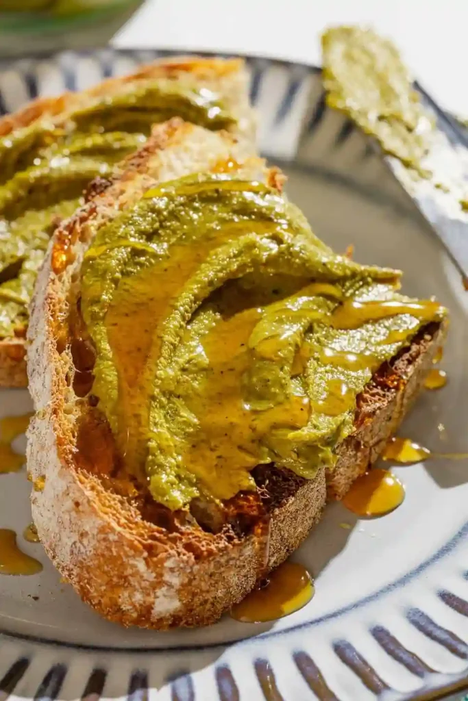 Frisches Brot mit cremiger Pistazienbutter und Honig verfeinert.