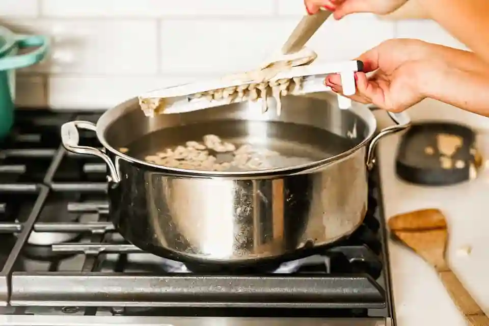 spätzleteig rezept – frischer Teig wird mit einem Hobel direkt ins kochende Wasser gegeben