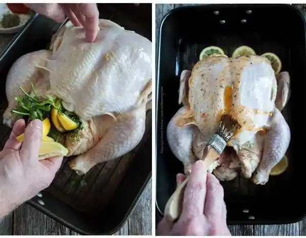 Halbes Hähnchen wird im Bräter mit frischen Kräutern und Zitrone gefüllt und anschließend mit gewürzter Butter bestrichen für das Backofenrezept.