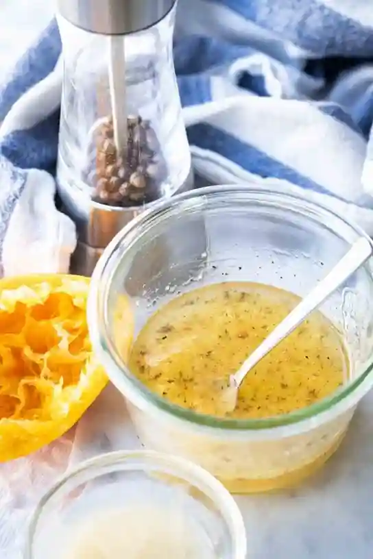 Salatdressing mit Zitrone für Omas Möhrensalat mit Apfel und Zitrone in einer Glasschüssel
