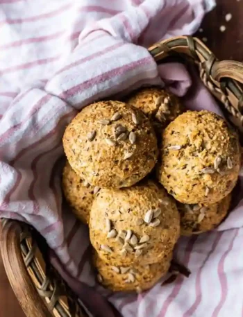 Frisch gebackene Sonntagsbrötchen ohne Hefe mit Haferflocken, Quark und Körnern in einem Brotkorb auf einem Küchentuch serviert