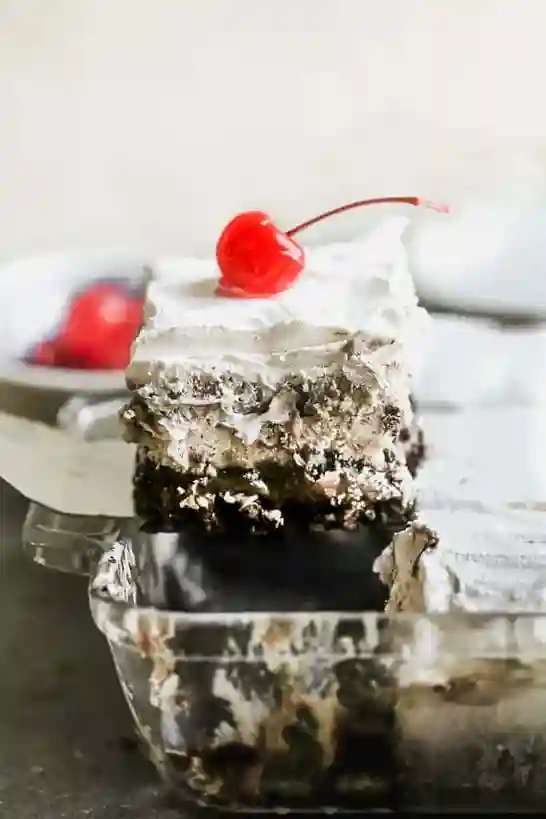 Eistorte selber machen mit luftiger Sahne, Eiscreme und lockerem Kuchenboden – servierbereit aus einer Glasform gehoben