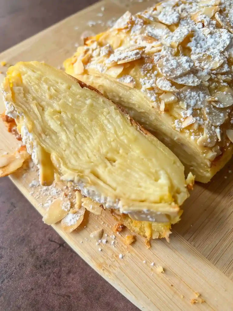 Französischer unsichtbarer Apfelkuchen aufgeschnitten mit feinen Apfelschichten und Mandel-Topping.