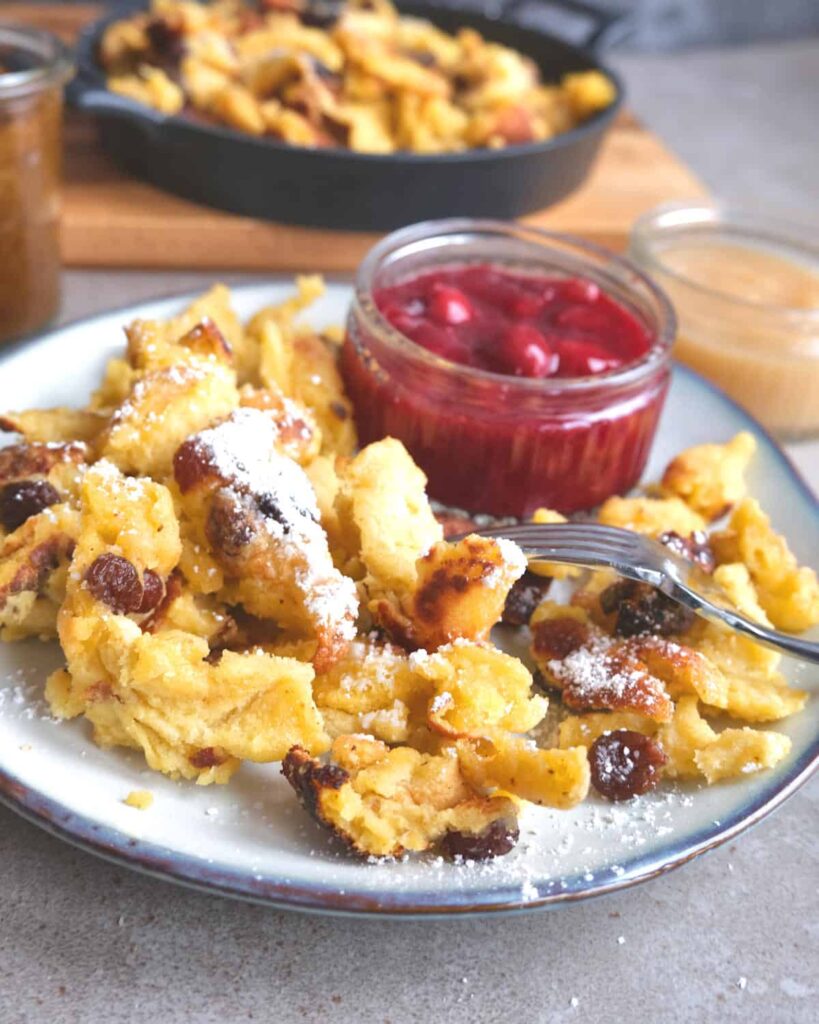 Original Kaiserschmarrn Rezept mit Rosinen und Apfelmus serviert mit Kirschkompott