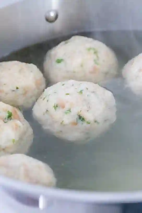 Klassische Semmelknödel beim Kochen im heißen Wasser