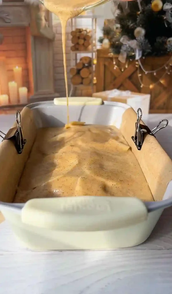 Französischer unsichtbarer Apfelkuchen – Teig wird über geschichtete Äpfel gegossen