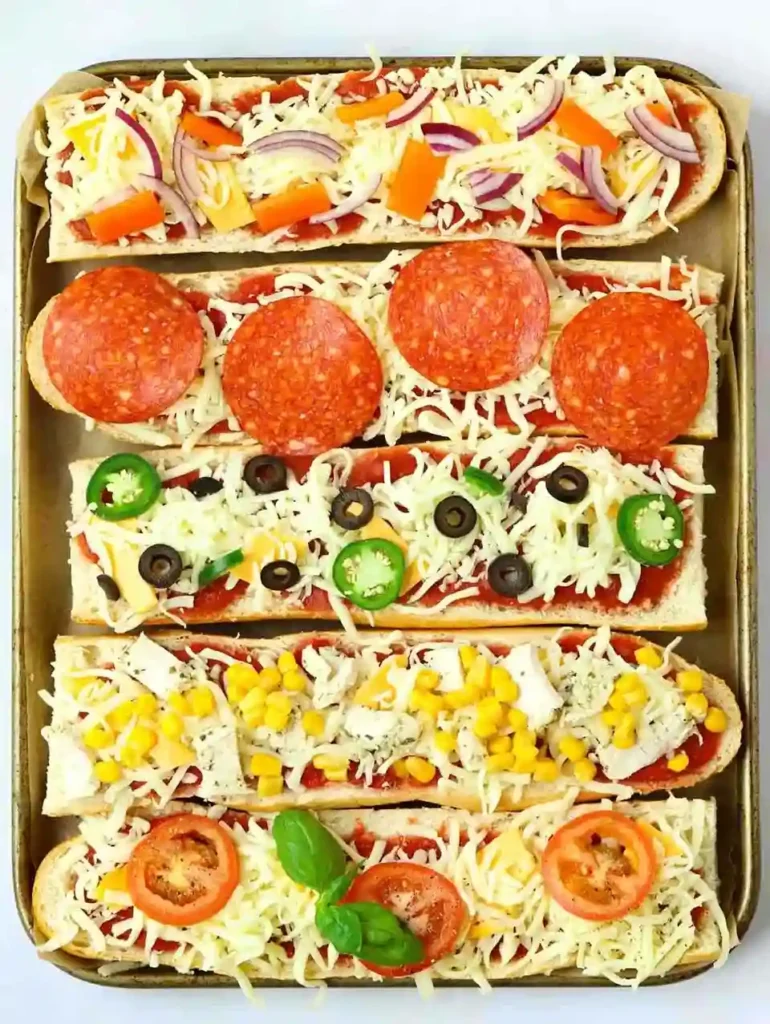 Belegte Baguettehälften mit bunten Zutaten für Pizza Baguette Rezept