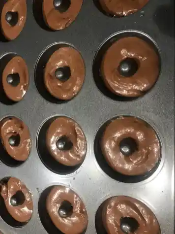 Schokoladenteig für Mini Donuts in einer Donut Backform vor dem Backen