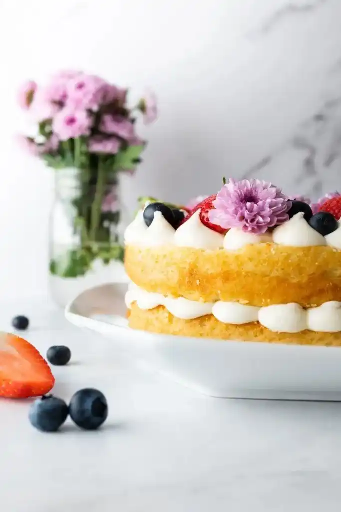 Seitlicher Blick auf eine Zahlentorte mit Biskuitboden, Vanillecreme und Beeren