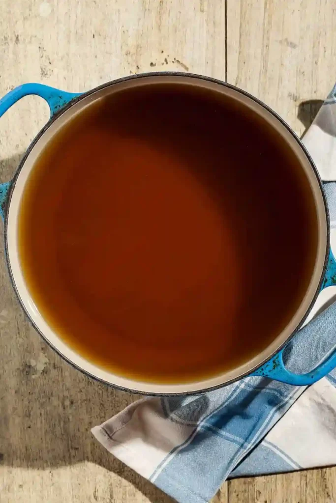 Hausgemachte Bio Gemüsebrühe ohne Salz in einem blauen Topf