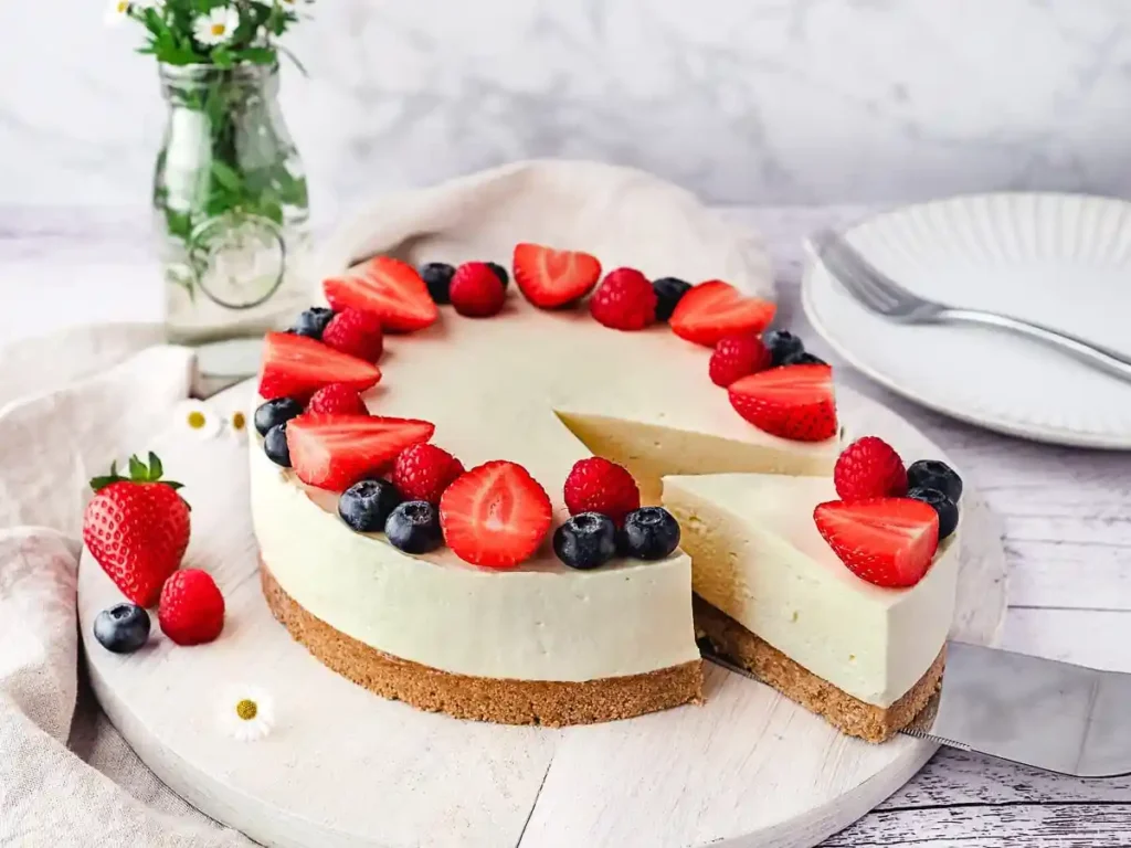 Philadelphia Frischkäsekuchen ohne Backen mit Beeren dekoriert und aufgeschnitten