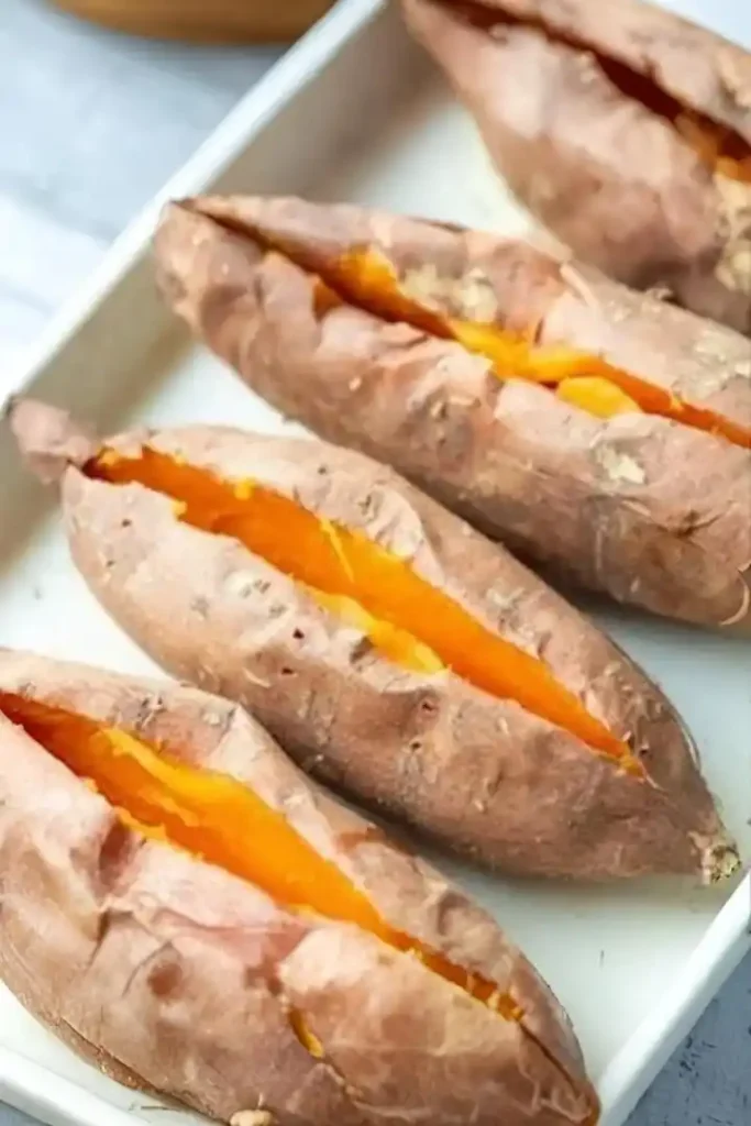 Ganze gebackene Süßkartoffeln im Ofen mit eingeschnittenem Schlitz zur Vorbereitung der Füllung
