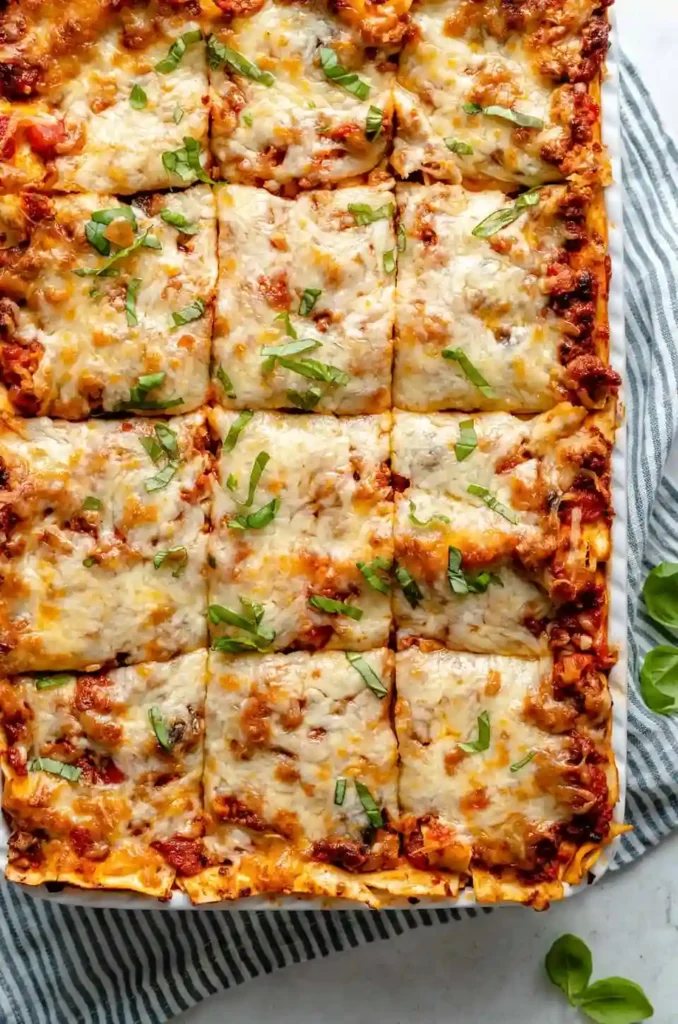 Aufgeschnittene vegane Lasagne Bolognese mit Gemüse und geschmolzenem veganem Käse in einer Auflaufform