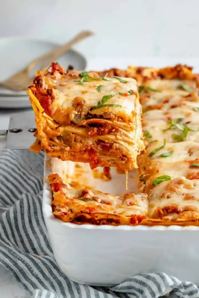 Stück vegane Lasagne Bolognese mit Gemüse frisch serviert
