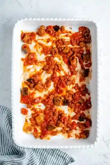 Vegane Bolognese-Sauce als erste Schicht in Auflaufform für Lasagne