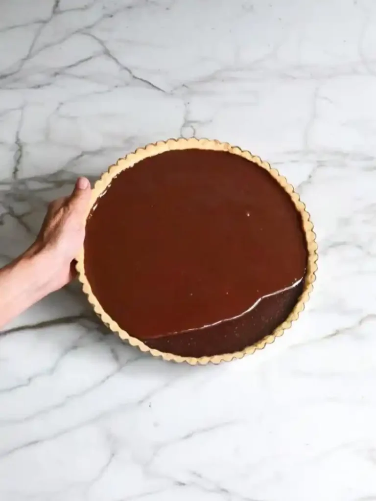 Tarte au Chocolat mit glänzendem Schokoladenguss – klassische französische Schokoladentarte auf Marmorplatte