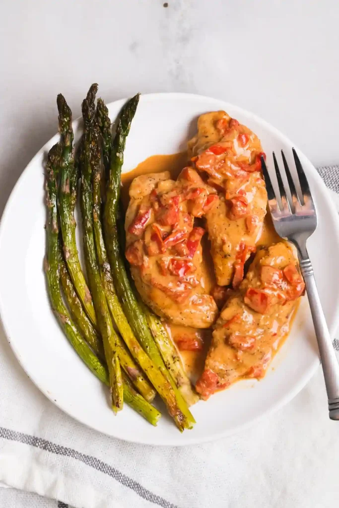 Paprika Sahne Hähnchen mit grünem Spargel auf Teller – cremige Pfanne mit Hähnchenfilet und Paprika