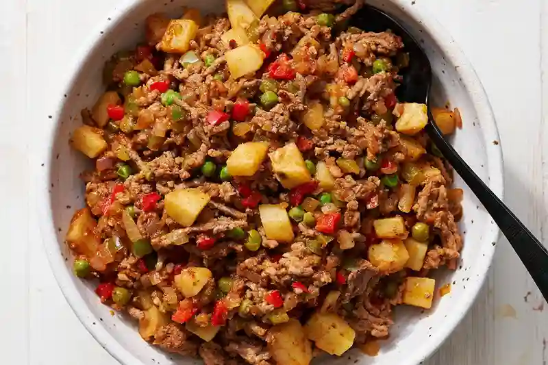 Schüssel mit Empanada Füllung aus Rinderhack, Kartoffeln, Paprika, Zwiebeln und Erbsen – würzige Mischung für argentinische Teigtaschen