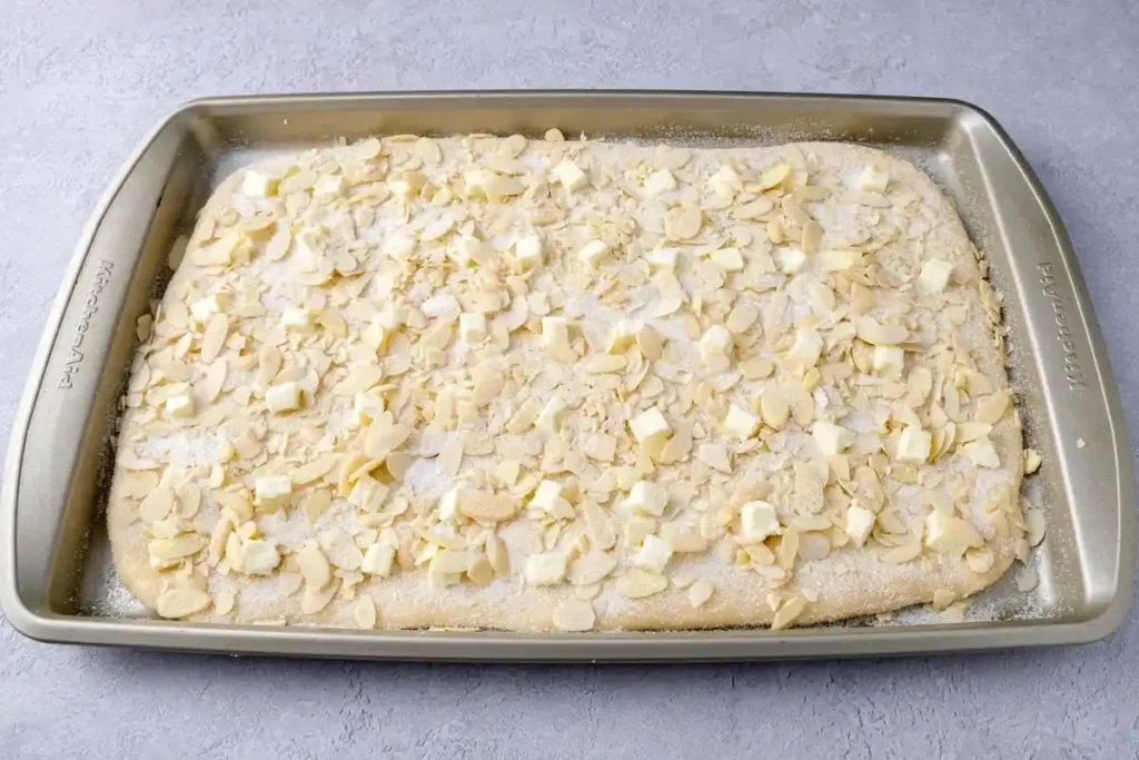 Butterkuchen ohne Hefe mit Mandelbelag vor dem Backen auf dem Blech