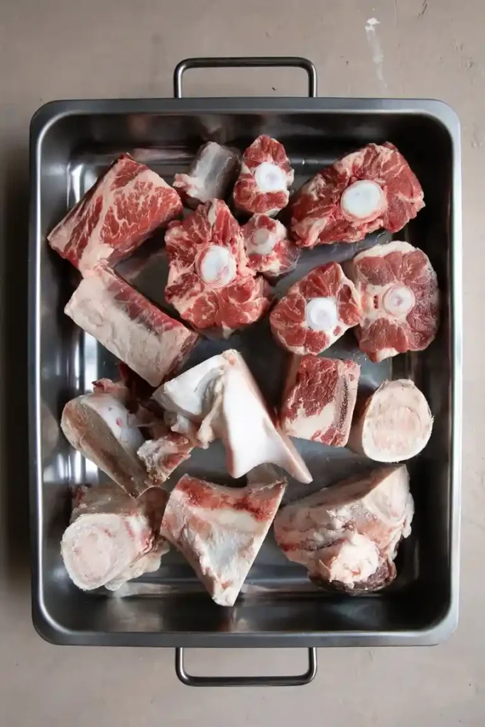 Rohe Rinderknochen und Markknochen in einer Bratform zur Vorbereitung für Knochensuppe