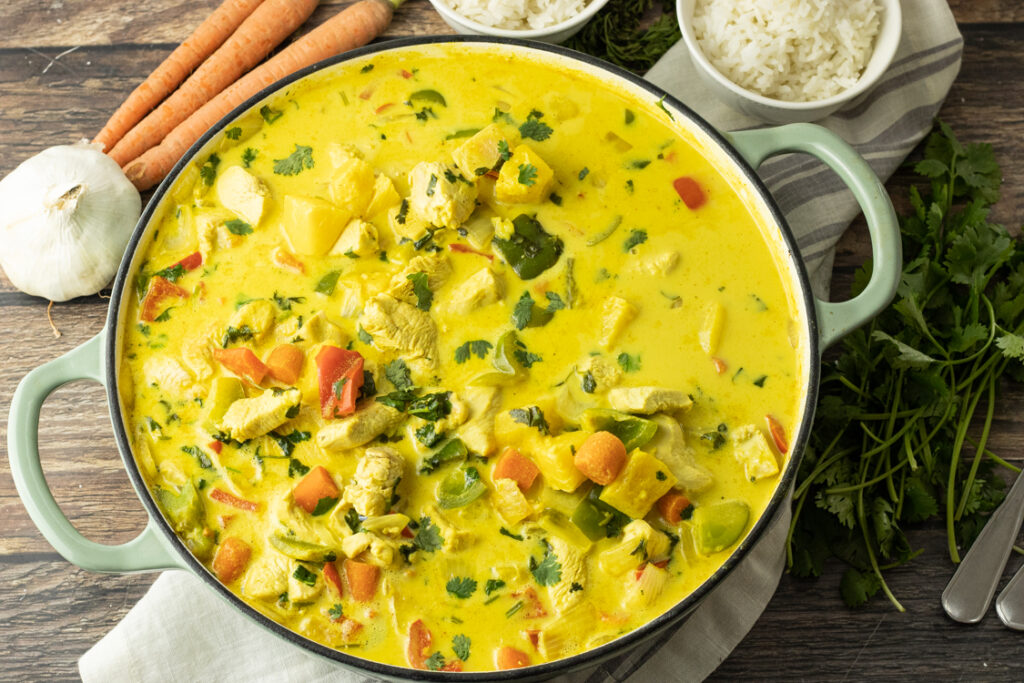 Hähnchen Curry mit Ananas und Kokosmilch in großer Pfanne serviert