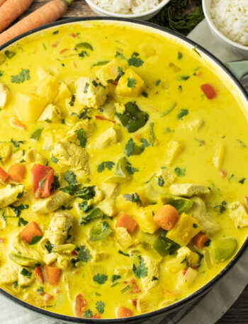 Hähnchen Curry mit Ananas und Kokosmilch in großer Pfanne serviert