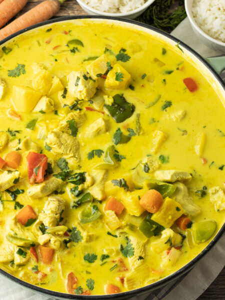 Hähnchen Curry mit Ananas und Kokosmilch in großer Pfanne serviert