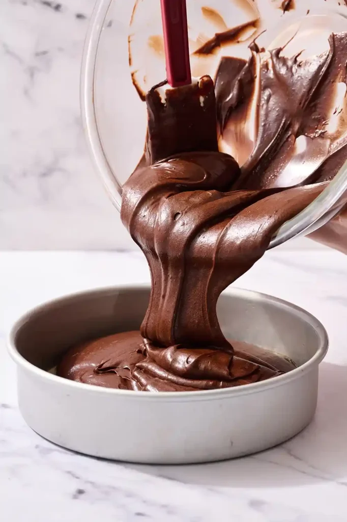 Teig für glutenfreien Schokoladenkuchen wird in Backform gefüllt