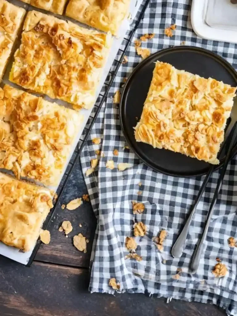 Blitzschneller Butterkuchen ohne Hefe in Stücke geschnitten auf Blech und Teller